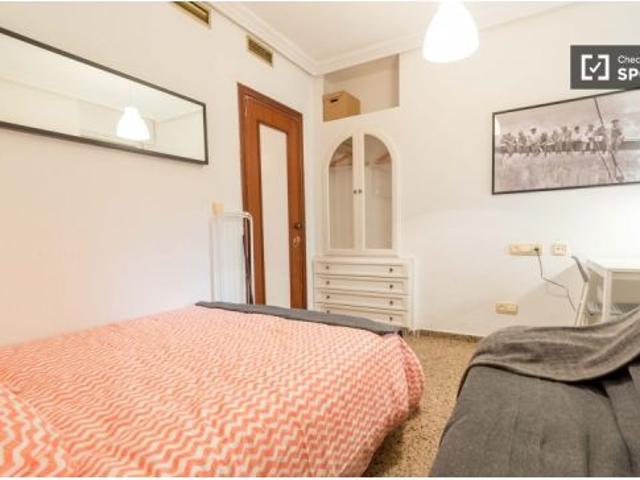 1 dormitorio con cama de matrimonio y balcón