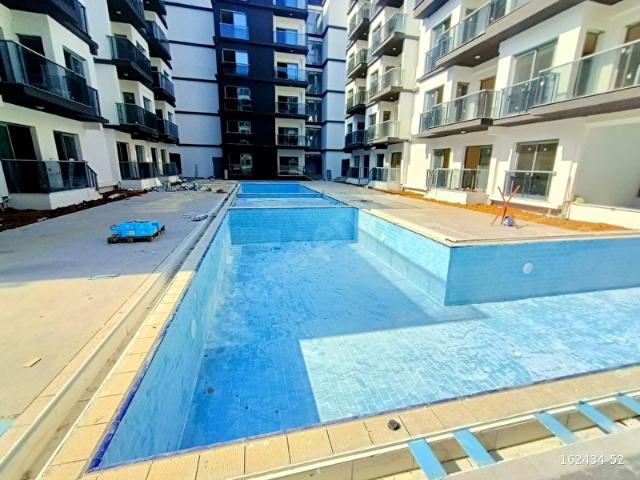 TATİL TADINDA OTURUM SUNAN HAVUZLU 2+1 BAHÇEKATI DAİRE SATILIK