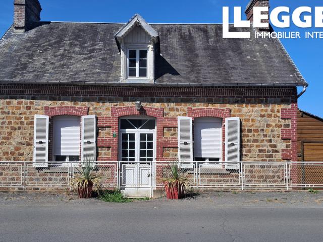 Une maison traditionnelle normande en pierre offrant une vue dégagée sur le village prisé de Lonlay l'Abbaye