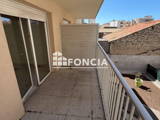 Appartement 3 pièces avec un grand balcon et une place de parking privative situé en plein centre ville