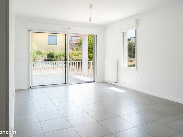 Appartement de trois pièces avec terrasse en rez de jardin, deux parkings en sous sol proche des commodités, des écoles et de la plage