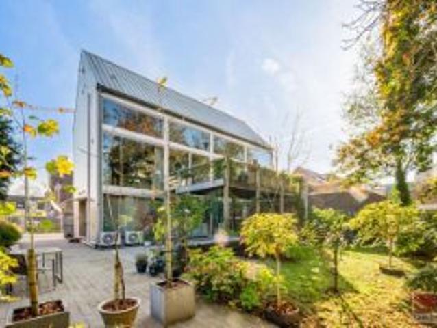 Architectenwoning met stalen constructie en glazen achter.