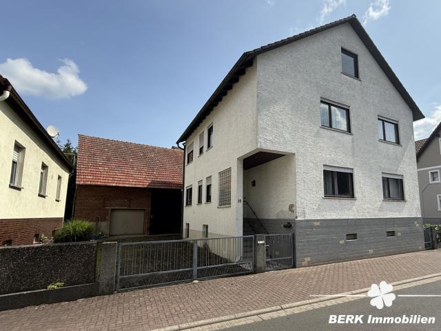 BERK Immobilien Charmantes Einfamilienhaus mit zwei Wohneinheiten und großzügiger Scheune + Garage