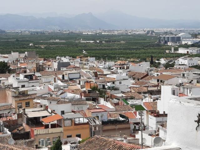 Casa adosada en venta en Oliva, Oliva Pueblo. La puerta principal se abre a un salón y comedor espacioso y lleno de luz, donde techos de vigas de madera expuestas, una chimenea. Casas adosadas.
