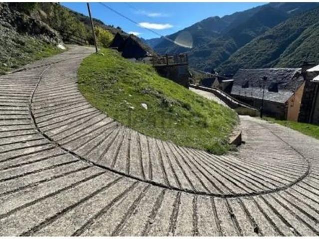 Casa rural aranesa histórica con borda y vistas panorámicas al Pirineo