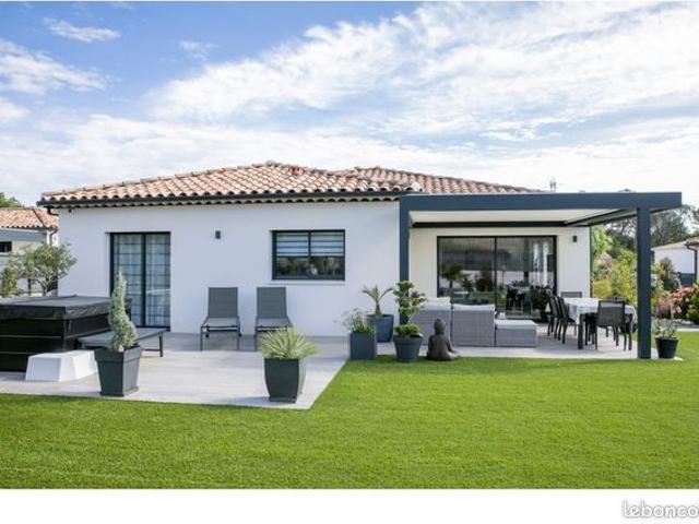 Cette maison de plain pied de 106 m² avec une architecture en L et classe énergie A, offre un cadre