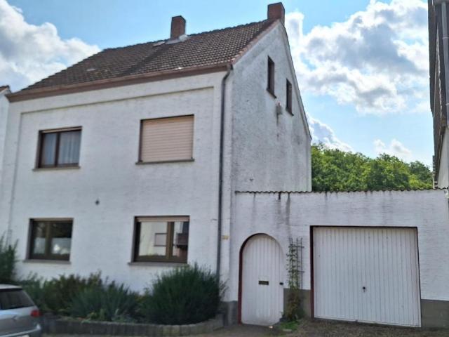 Ein Zweifamilienhaus mit Schwimmhalle und Garage