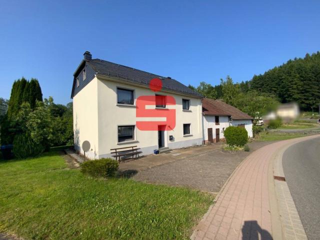 Einfamilienhaus mit Nebengebäuden auf großem Grundstück