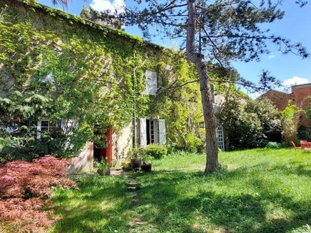 Grande maison en pierres sur joli parc arboré