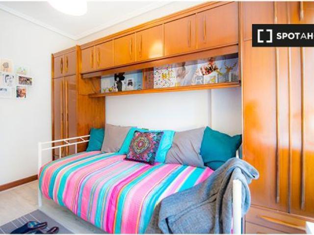 Habitación soleada con estantería en un apartamento de 3 dormitorios en Uribarri