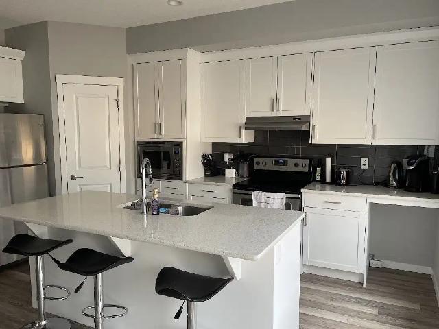 Home with basement kitchenette, fenced yard, and heated oversized double garage