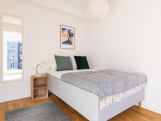 Møbleret værelse i moderne lejlighed på Sluseholmen