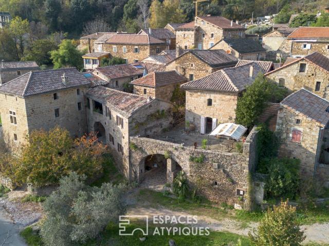 Ancienne magnanerie en pierre, rénovée, nichée dans un village
