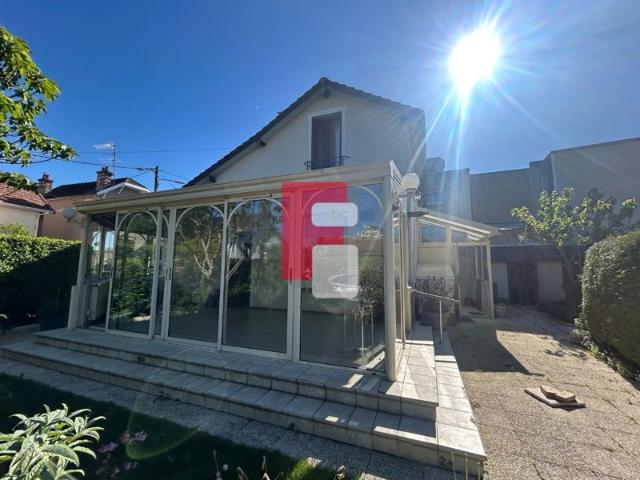 Maison familiale avec véranda et grand garage sur un terrain