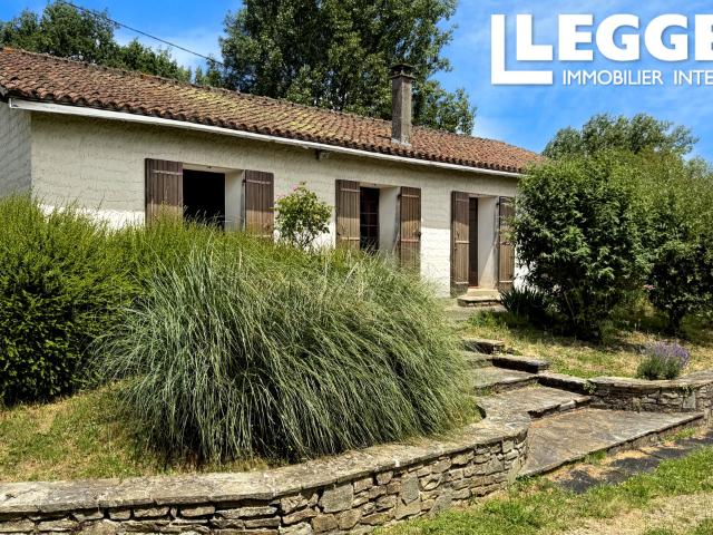 Maison plain pied en pierre élevée sur une grande garage avec trois chambres et joli jardin. Périgord Vert