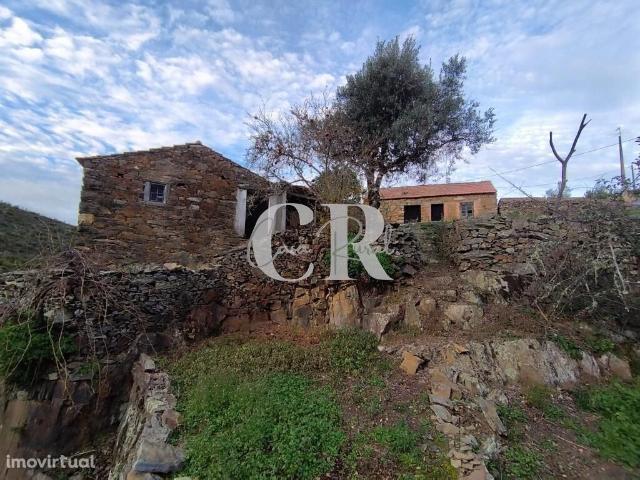 Moradias em pedra, para recuperar, a confrontar com ribeira em Oleiros