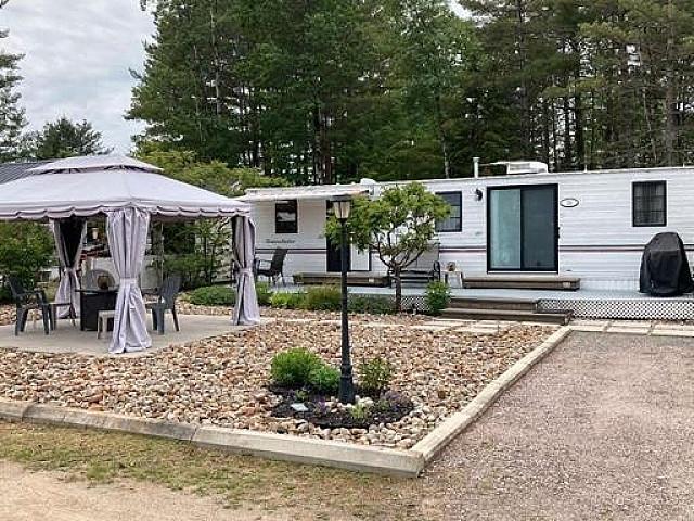 Park Model Trailer On Landscaped Lot With Water Access