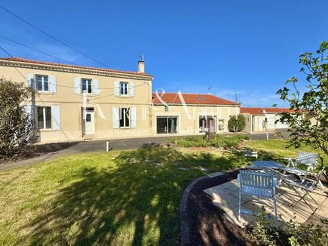 Propriété offrant trois garages, préau, jardin clos ainsi qu'un appartement