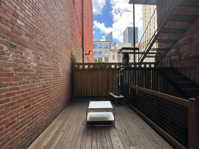 Studio historique des années 1800 dans le Vieux Montréal avec terrasse et vue sur les gratte ciel